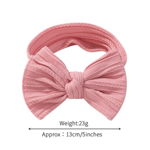 Pink oversized bow baby headband with ribbed nylon texture and 13cm wide elastic fit