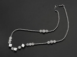 Detail of hip hop necklace with steel beads, cracked glass beads and silver dice charms