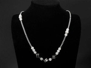 Detailed view of punk necklace with silver beads, faux pearls and metal dice charms