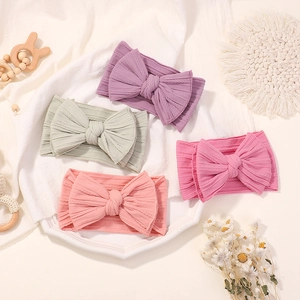 Set of four soft nylon baby headbands with large bows in various pastel colors