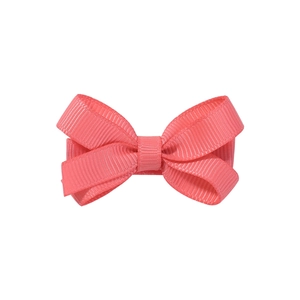 Détail du nœud papillon en ruban gros-grain rose corail pour cheveux d'enfants