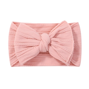 Detailed texture of pink elastic nylon headband with a soft knit bow for babies