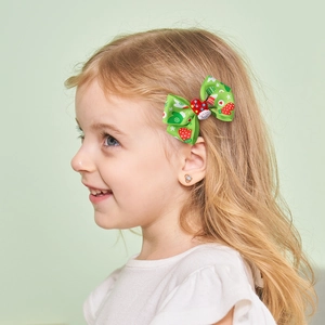 Christmas bow hair clip with Santa Claus pattern for girls shown on model