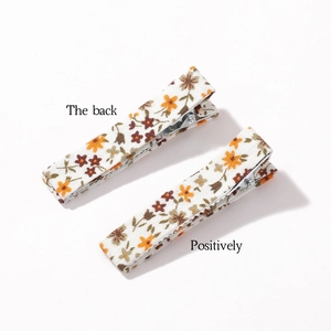 Set of two floral fabric hair clips in beige with orange and brown flower patterns