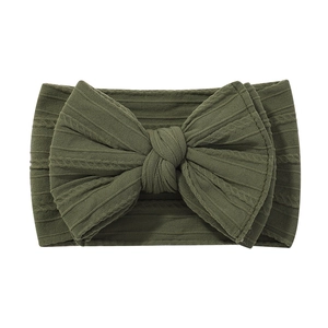 Detailed view of dark green ribbed fabric baby headband with a large matching bow