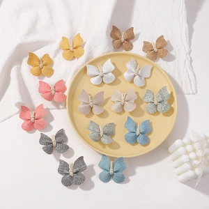 Vue détaillée de pinces à cheveux papillon artisanales en cuir PU en couleurs pastel
