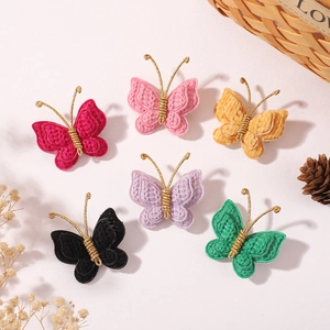 Detailed view of six colorful handmade butterfly knitted hair clips on a rustic surface