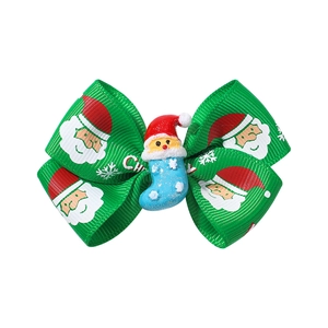 Detail of Christmas bow hair clip with Santa Claus figurine on green ribbon