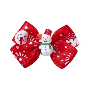 Detail of Christmas bow hair clip featuring a resin snowman and printed red ribbon