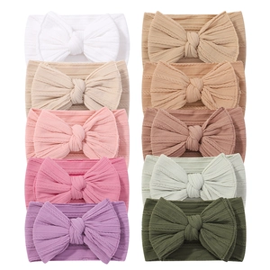 Set of 10 solid color elastic baby headbands with large ribbed fabric bows in assorted colors