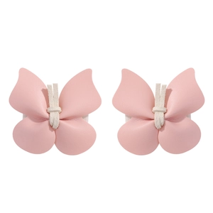 Gros plan de pinces à cheveux papillon en cuir PU rose avec nœud central blanc doux