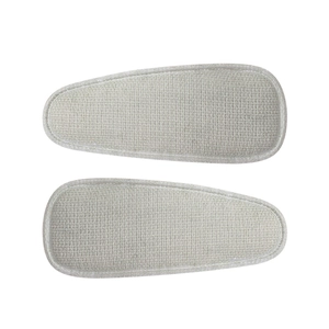 Close-up of beige linen fabric BB hair clips with detailed stitching on white background