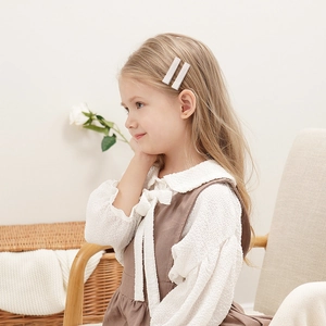 Lot de deux barrettes blanches à paillettes pour enfants portées sur les cheveux latéraux