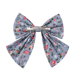 Floral print fabric bow hair clip in grey-blue with pink blossom patterns for girls
