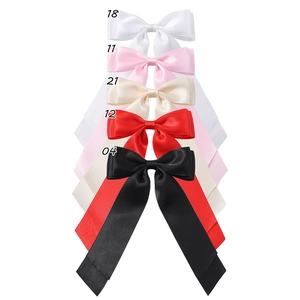 Détail de barrettes à nœuds en ruban de satin coloré en blanc, rose, beige, rouge et noir