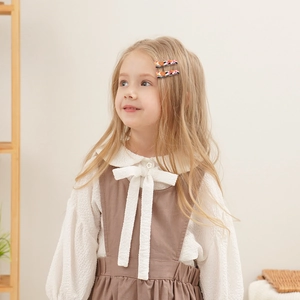 Girl wearing a two-piece floral cotton linen hair clip set in a cozy home setting