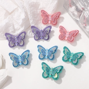 Gros plan de barrettes papillon en strass étincelants aux diverses couleurs pastel