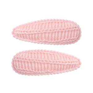 Detailed macro view of two pink knitted teardrop hair clips with woven texture