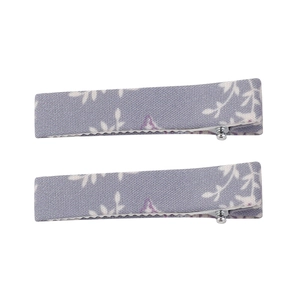Détail de deux barrettes en lin à imprimé fleuri avec tissu violet et pince crocodile