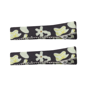 Close-up of floral print fabric hair clips with black background and beige flowers