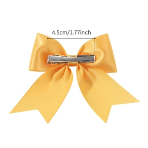 Bright yellow satin bow hair clip with silver metal alligator grip on white background