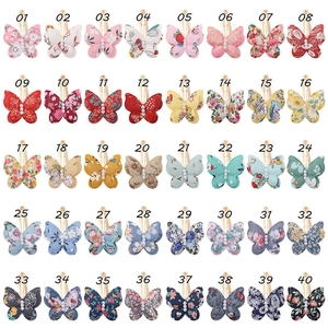 Detail view of 40 styles of floral fabric butterfly hair clips with pearl beads