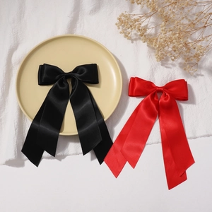 Elegant double-layered satin bow hair clips in black and red with long flowing ribbons