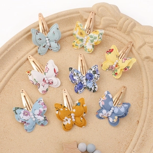 Set of 8 floral print fabric butterfly hair clips with pearl accents on vintage tray