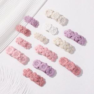 Dettaglio di un set da 13 pezzi con fermagli per capelli ricamati in rosa e viola pastello