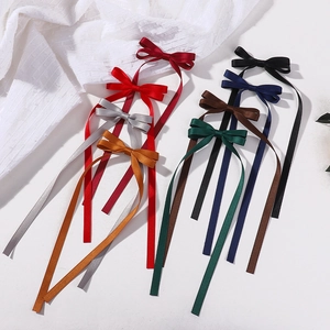 Detailed macro view of multi-colored satin bow hair clips with long elegant ribbons