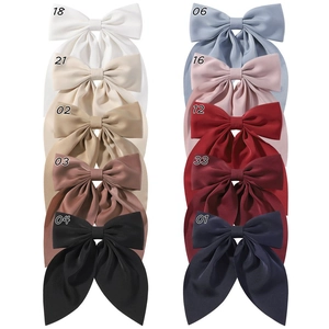 Detail showing ten colors of double-layered satin bow hair clips with long ribbons