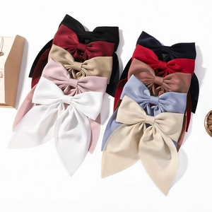 Elegant oversized satin hair bows in multiple colors with long trailing ribbons and clips