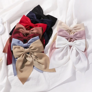 Vue détaillée de diverses grandes barrettes à nœuds en satin dans plusieurs couleurs