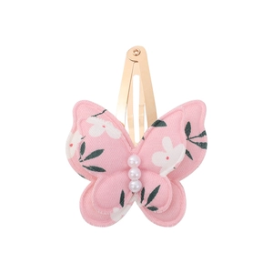 Detail of pink floral butterfly hair clip with white faux pearls and gold metal BB clip