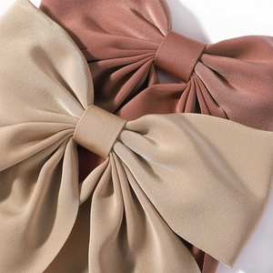 Solid color oversized satin bow hair clips in champagne gold and vintage rose pink