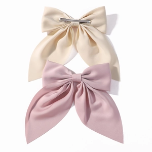 Large solid color oversized bow hair clips in cream and pink for girls and women