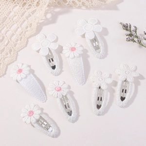 Vue détaillée d'un lot de 8 barrettes à fleurs blanches brodées avec bordure en dentelle