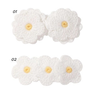 Dettaglio di fermagli per capelli a forma di fiori bianchi fatti a mano con accenti gialli