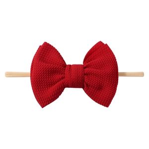 Detailed view of large red popcorn fabric baby headband with textured waffle knit bow