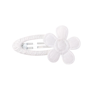 Gros plan sur la barrette marguerite brodée blanche avec texture de tissu premium