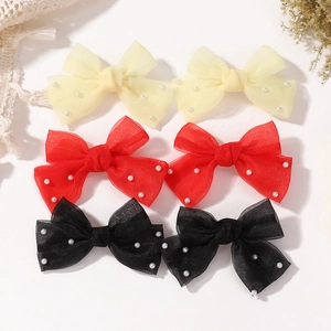 Détail de pinces à cheveux en tulle avec perles, couleurs jaune, rouge et noir