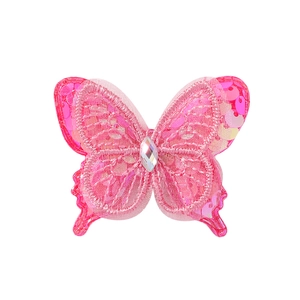 Détail de pince à cheveux papillon en dentelle rose avec paillettes et strass brillants