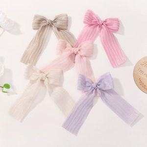 Détail de cinq nœuds papillons pastel avec longs rubans et fins reflets scintillants