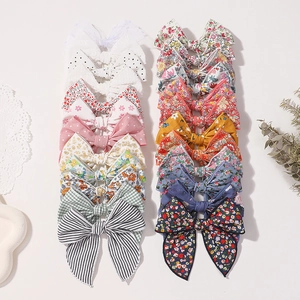 Vue à plat de 20 barrettes à cheveux en coton à carreaux et fleurs sur papier dentelle