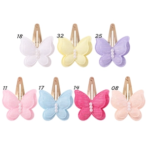 Détail de pinces à cheveux papillon double couche colorées avec paillettes et perles