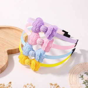 Close-up of four macaron-colored crochet bow headbands on a clean white background
