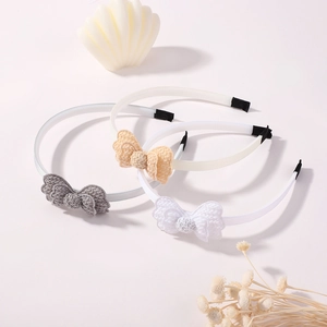 Detail view of handmade crochet lace bow headbands in grey, beige, and white colors