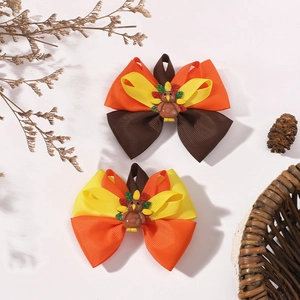 Detail showing two Thanksgiving turkey bow hair clips with textured grosgrain ribbon