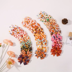 Detail of autumn-themed bow clips set with turkey, pumpkin and maple leaf patterns