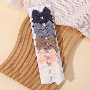 Dettaglio di 10 fermagli per capelli con fiocco a righe in cinque colori vintage su carta